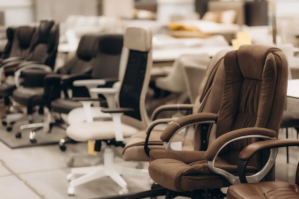 used-vs-new A modern, well-furnished Atlanta startup office featuring a mix of new ergonomic chairs and high-quality pre-owned desks.